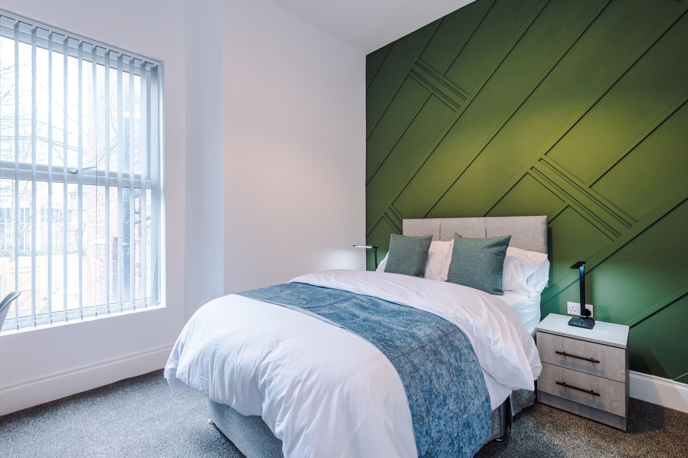 Furnished double room with green panelled wall